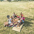 Eine Gruppe von Menschen picknickt im Park © GettyImages