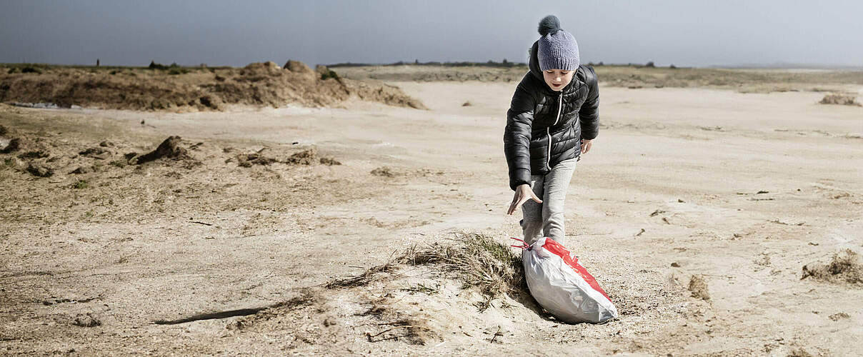 Kind sammelt Müll am Strand © Red Star