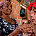 Wayuu Frau bemalt auf tradionelle Art ihre Enkelin in Kolumbien © IMAGO / SOPA Images